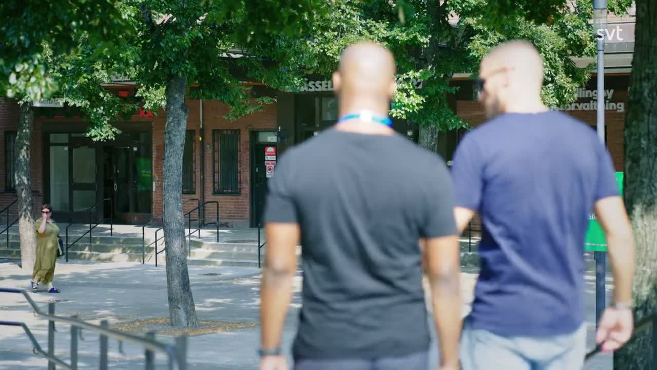 Två vuxna sedda bakifrån i gatumiljö